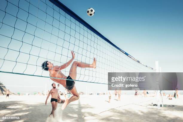 brasileira homem pulando de soccerball voleibol líquido no rio de janeiro - beach volleyball - fotografias e filmes do acervo