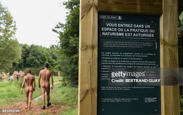 Graphic content / Two naked people walk past a sign reading "you are entering a space where the practise of naturism is authorised" at a newly opened...