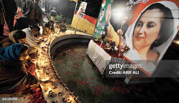 Activists of Pakistan People's Party light earthen lamps on the eve of the first death anniversary of slain former premier Benazir Bhutto in Lahore...
