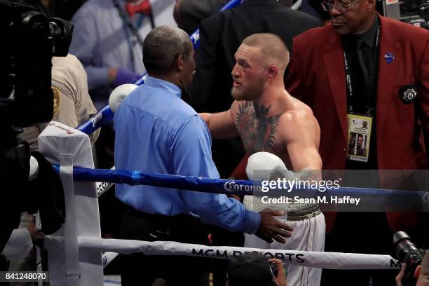 Conor McGregor speaks to referee Robert Byrd after losing to Floyd Mayweather Jr. By 10th round TKO in their super welterweight boxing match on...