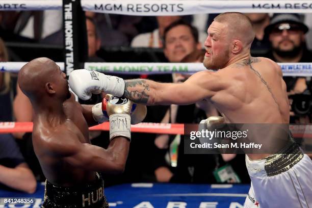 Conor McGregor throws a punch at Floyd Mayweather Jr. During their super welterweight boxing match on August 26, 2017 at T-Mobile Arena in Las Vegas,...