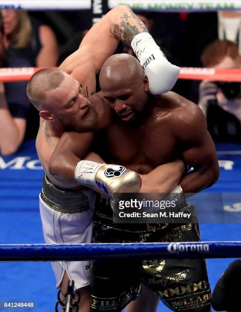 Floyd Mayweather Jr. And Conor McGregor hold during their super welterweight boxing match on August 26, 2017 at T-Mobile Arena in Las Vegas, Nevada.