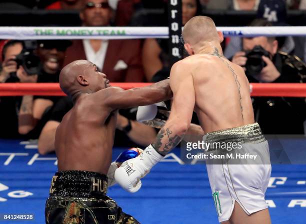Floyd Mayweather Jr. Throws a punch at Conor McGregor during their super welterweight boxing match on August 26, 2017 at T-Mobile Arena in Las Vegas,...