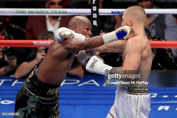 Floyd Mayweather Jr. Throws a punch at Conor McGregor during their super welterweight boxing match on August 26, 2017 at T-Mobile Arena in Las Vegas,...