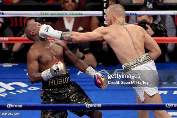 Conor McGregor throws a punch at Floyd Mayweather Jr. During their super welterweight boxing match on August 26, 2017 at T-Mobile Arena in Las Vegas,...