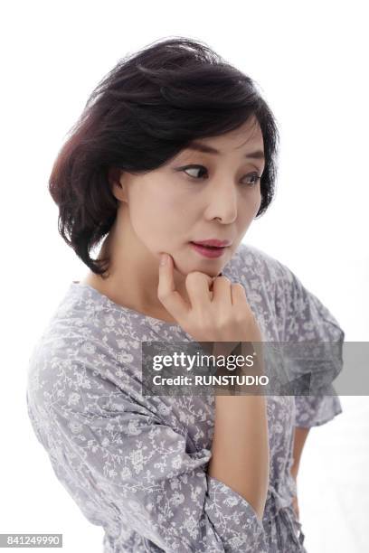 middle aged woman with her hand on her chin - ミディアムヘア ストックフォトと画像