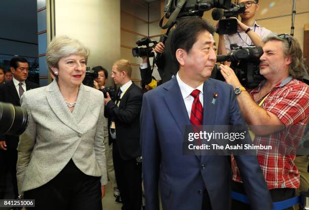 British Prime Minister Theresa May is escorted by Japanese Prime Minister Shinzo Abe prior to a National Security Council meeting at Abe's official...