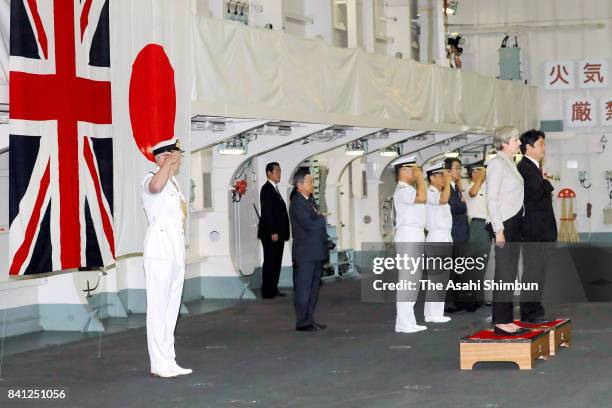 British Prime Minister Theresa May and Japanese Defense Minister Itsunori Onodera listen to the national anthems at Japan Maritime Self-Defense Force...