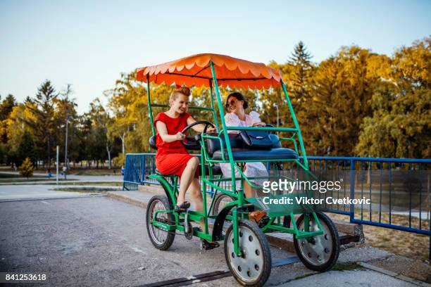 jeunes femmes amis se moquent avec quadricycle - quadricycle photos et images de collection