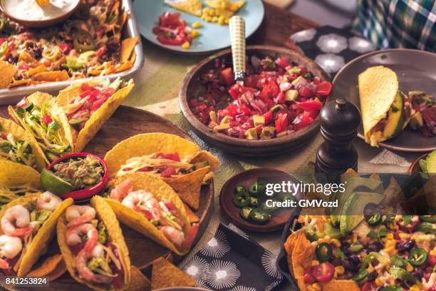 mexikanische tacos mit scharfer salsa und nacho-tortilla-chips essen - mexiko stock-fotos und bilder