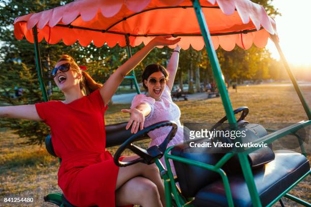 jeunes femmes amis se moquent avec quadricycle - quadricycle photos et images de collection