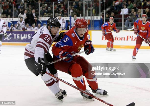 Artjoms Ogorodnikovs of Latvia battles for the loose puck with Maxim Goncharov in Ottawa, Ontario, Canada.