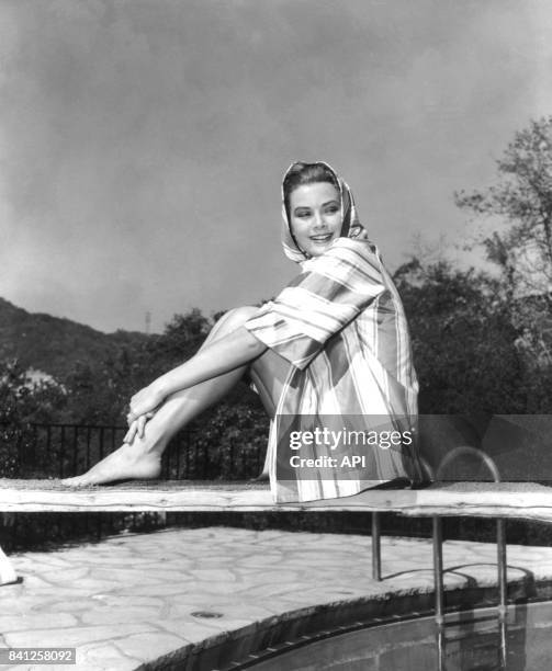 Portrait de l'actrice Grace Kelly assise sur un plongeoir en 1954.