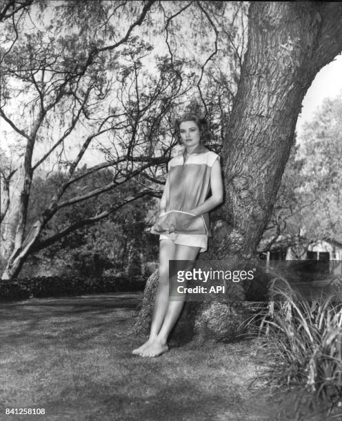 Portrait de l'actrice Grace Kelly appuyée contre un tronc en 1954.