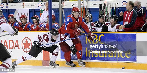 Janis Ozolins of Latvia tries to slow down Sergei Andronov of Russia for the loose puck at the Civic Centre on December 26, 2008 in Ottawa, Ontario,...
