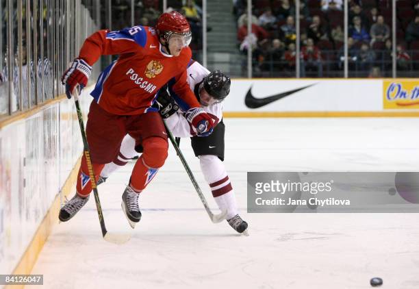 Janis Smits of Latvia chases Evgeni Grachev of Russia as he carries the puck at the Civic Centre on December 26, 2008 in Ottawa, Ontario, Canada.