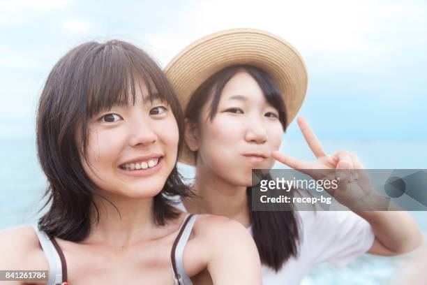 ビーチで selfie を取って二人の若い女性 - 自分撮り ストックフォトと画像