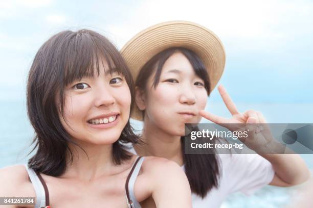 two young women taking selfie on the beach - self portrait photography stock pictures, royalty-free photos & images