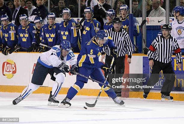 Nestori Lahde of Finland uses his stick to hook Erik Karlsson of Sweden at the Civic Centre on December 26, 2008 in Ottawa, Ontario, Canada.