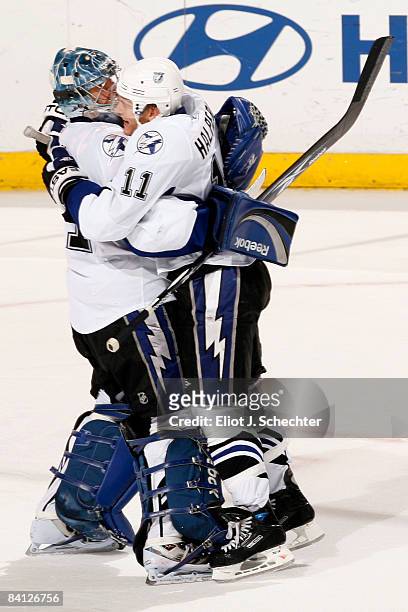 Goaltender Mike Smith of the Tampa Bay Lightning celebrates with teammate Jeff Halpern after a win against the Florida Panthers in overtime at the...