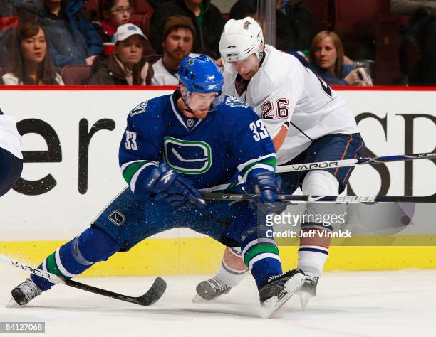 Erik Cole of the Edmonton Oilers and Henrik Sedin of the Vancouver Canucks battle along the boards during their game at General Motors Place on...