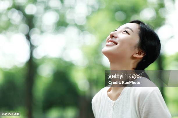 young lady laughing at the park - woman looking up bildbanksfoton och bilder