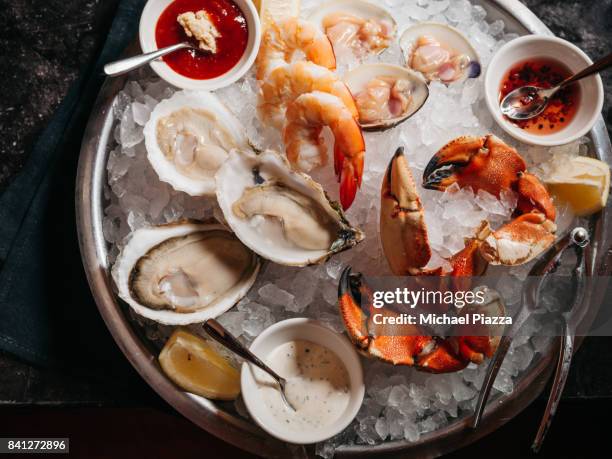 raw platter with oysters, clams, shrimp, and lobster claws - seafood platter stockfoto's en -beelden