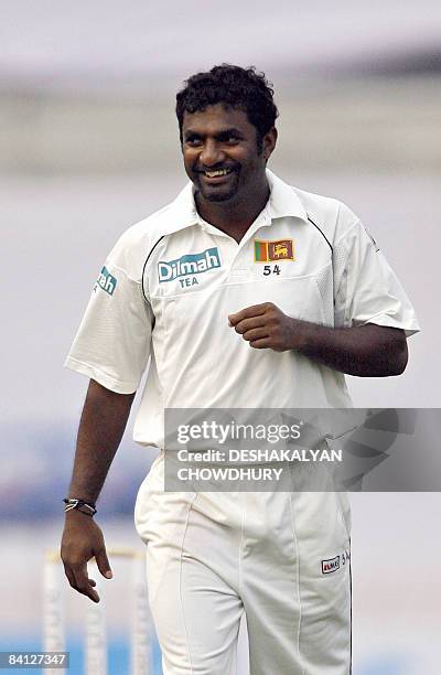 Sri Lankan cricketer Muttiah Muralitharan gestures as he prepares to bowl during the second day's play of the first Test match between Bangladesh and...