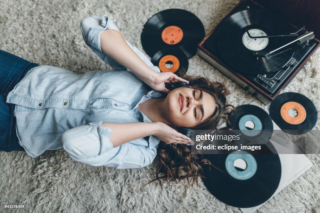 Young woman enjoing music from gramophone