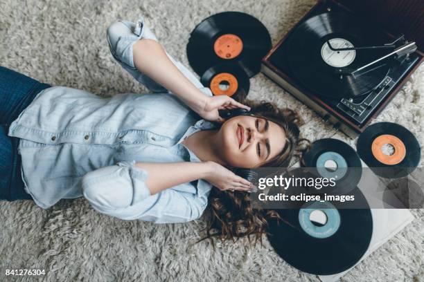 young woman enjoing music from gramophone - vinyl records stock pictures, royalty-free photos & images