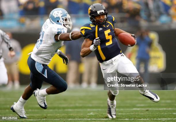 Da'Norris Searcy of the North Carolina Tar Heels grabs Pat White of the West Virginia Mountaineers during the Meineke Car Care Bowl on December 27,...