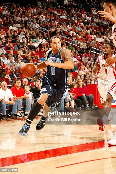 Deron Williams of the Utah Jazz drives the ball past Aaron Brooks of the Houston Rockets on December 27, 2008 at the Toyota Center in Houston, Texas....