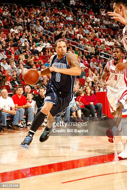 Deron Williams of the Utah Jazz drives the ball past Aaron Brooks of the Houston Rockets on December 27, 2008 at the Toyota Center in Houston, Texas....