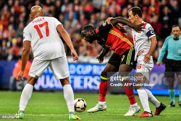 Gibraltar's Jason Pusey, Belgium's Romelu Lukaku and Gibraltar's Roy Chipolina vie for the ball during the WC 2018 football qualification football...