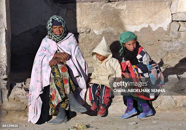 Abdelfettah FAKIHANI A woman and her children sit on the sidewalk in the village of Imilchil, a village situated at 2200m altitude at the heart of...