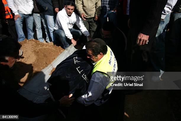 Man carries the dead body of Beber Vaknin, who was killed by a Palestinian rocket, into his grave on December 28, 2008 in the southern city of...