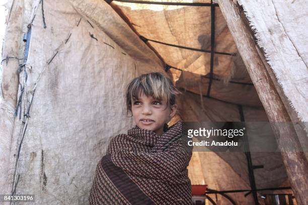 Syrian refugee girl, fled from Syrian city of Aleppo due to Assad Regime and Daesh terrorists' assaults, is seen outside of the makeshift tents near...