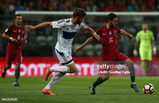 Portugal midfielder Joao Moutinho with Faroe Island defender Rogvi Baldvinsson in action during the FIFA 2018 World Cup Qualifier match between...