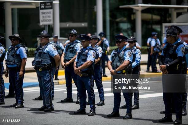 Police officers stand guard during a union protest against austerity measures in San Juan, Puerto Rico, on Wednesday, Aug. 30, 2017. The federal...