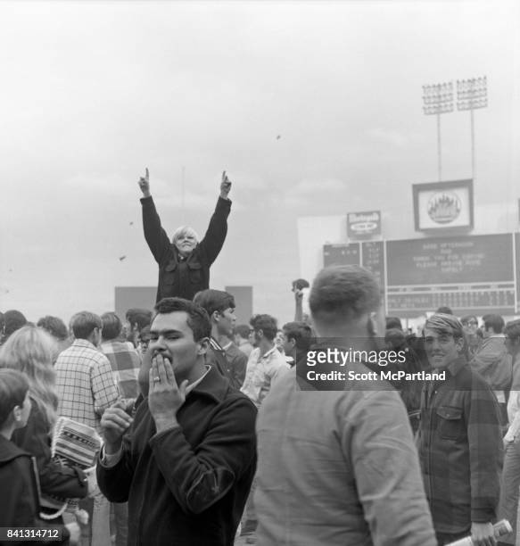 Shea Stadium : Dirt and grass can be seen being thrown into the air, and a young boy throws his arms up in victory, as fans storm the field at Shea,...