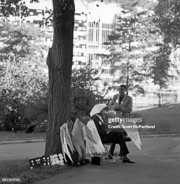 Shea Stadium : 2 men sit outside of Shea Stadium, and peddle NY Mets World Series Banners and Buttons prior to Game 5 beginning