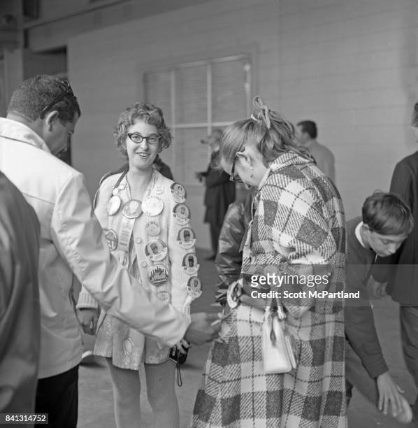 Shea Stadium : A female NY Mets fan in classic 60s style, smiles at the camera, and is decked out from head to toe in in all things Mets, prior to...