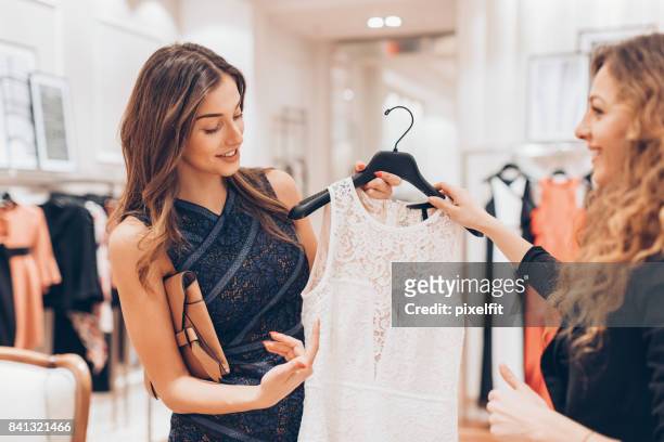 hogere klasse vrouw het kiezen van een nieuwe jurk - kanten jurk stockfoto's en -beelden