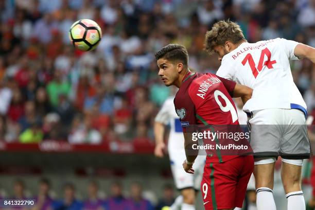 Portugal's forward Andre Silva heads the ball with Faroe Islands' defender Rogvi Baldvinsson during the 2018 FIFA World Cup qualifying football match...