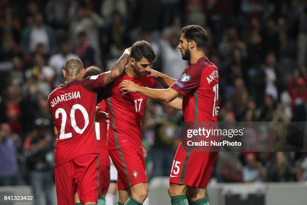 Portugal's forward Nelson Oliveira celebrates after scoring goal with teammates Portugal's forward Ricardo Quaresma and Portugal's midfielder Andre...