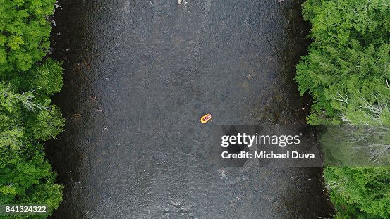 Aerial view of a man Rafting down a river lazily
