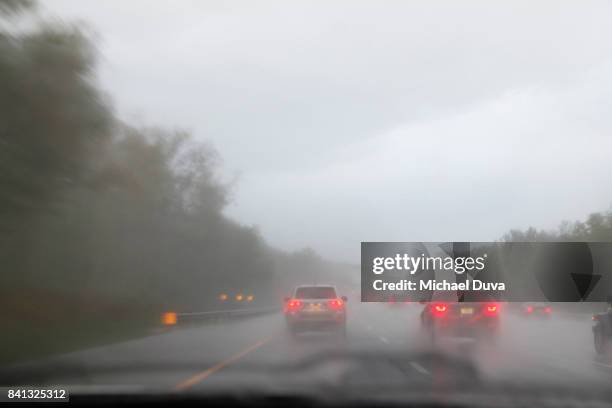 cars driving on a rainy foggy multi lane highway at dusk - tail light stock pictures, royalty-free photos & images