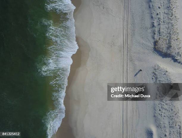 directly overhead view of two people on a beach looking at the ocean - tyre track stock pictures, royalty-free photos & images