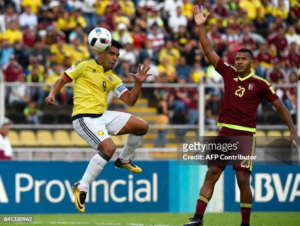 Colombia's Radamel Falcao heads the ball next to Venezuela's Salomon Rondon during their 2018 World Cup qualifier football match, in San Cristobal,...