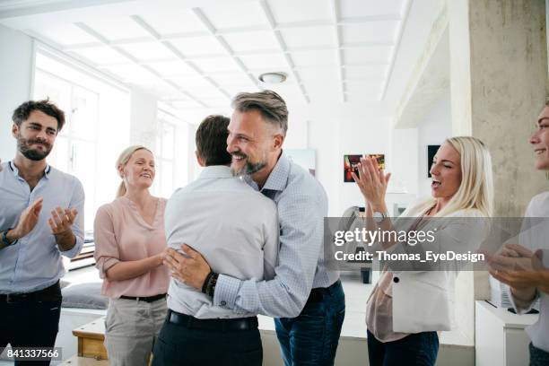 celebrations in office after successful business pitch by team - hug imagens e fotografias de stock